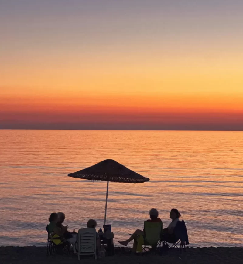 amigos en la playa mirando el atardecer