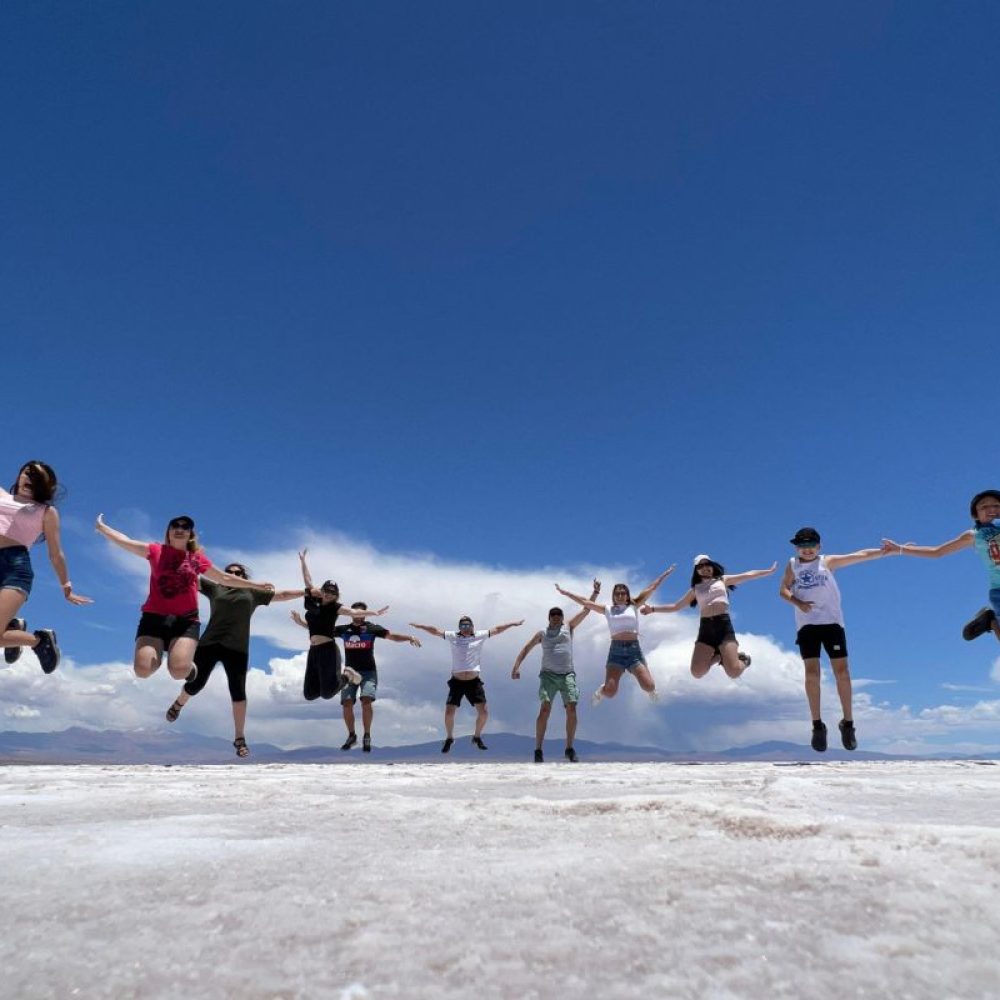 Familia de turistas, saltando felices en las Salinas Grandes, Jujuy